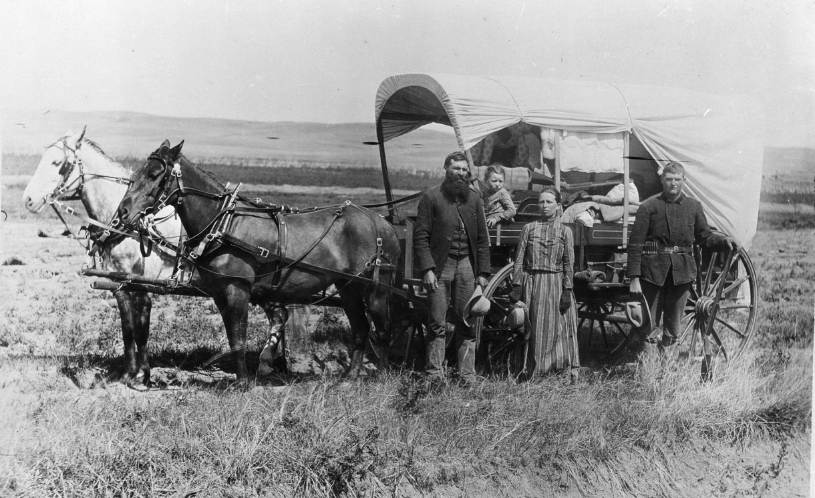 Family with covered wagon and horses