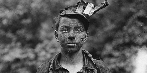 Boy with a dirty face and kerosene headlamp on his head