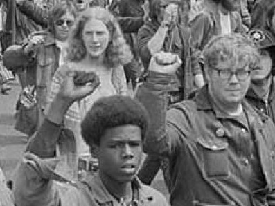 Young adults marching and protesting with fists raised