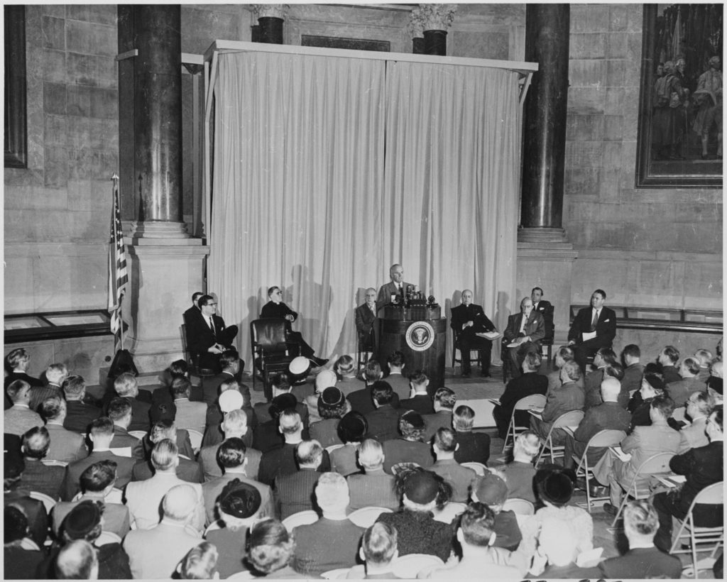 President Truman Giving a Speech at a Podium with a Crowd Watching